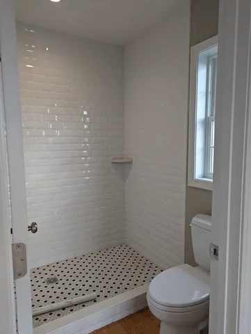 a bathroom with a toilet and a shower