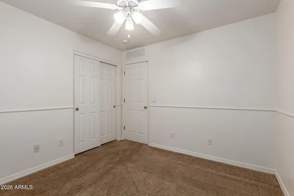 an empty room with a chandelier fan