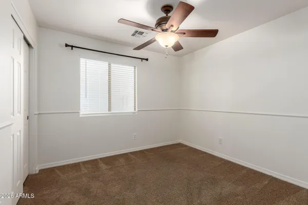 an empty room with a window and a ceiling fan
