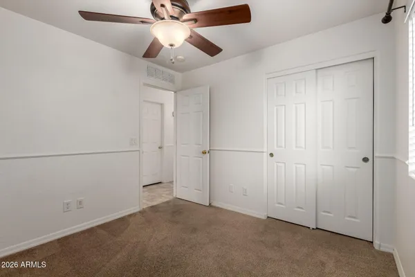 an empty room with chandelier fan
