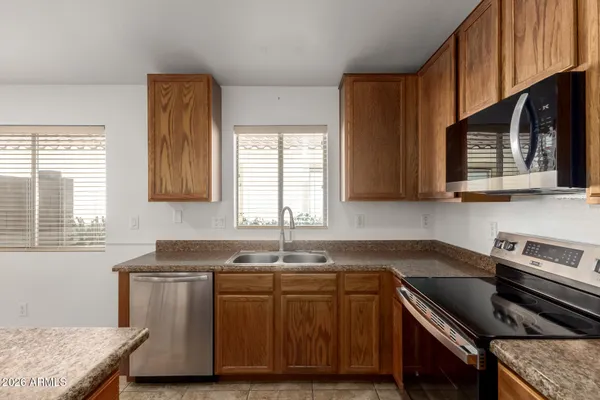 a kitchen with granite countertop a sink a stove and cabinets