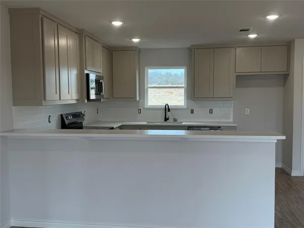 a kitchen with stainless steel appliances a sink a stove and a refrigerator