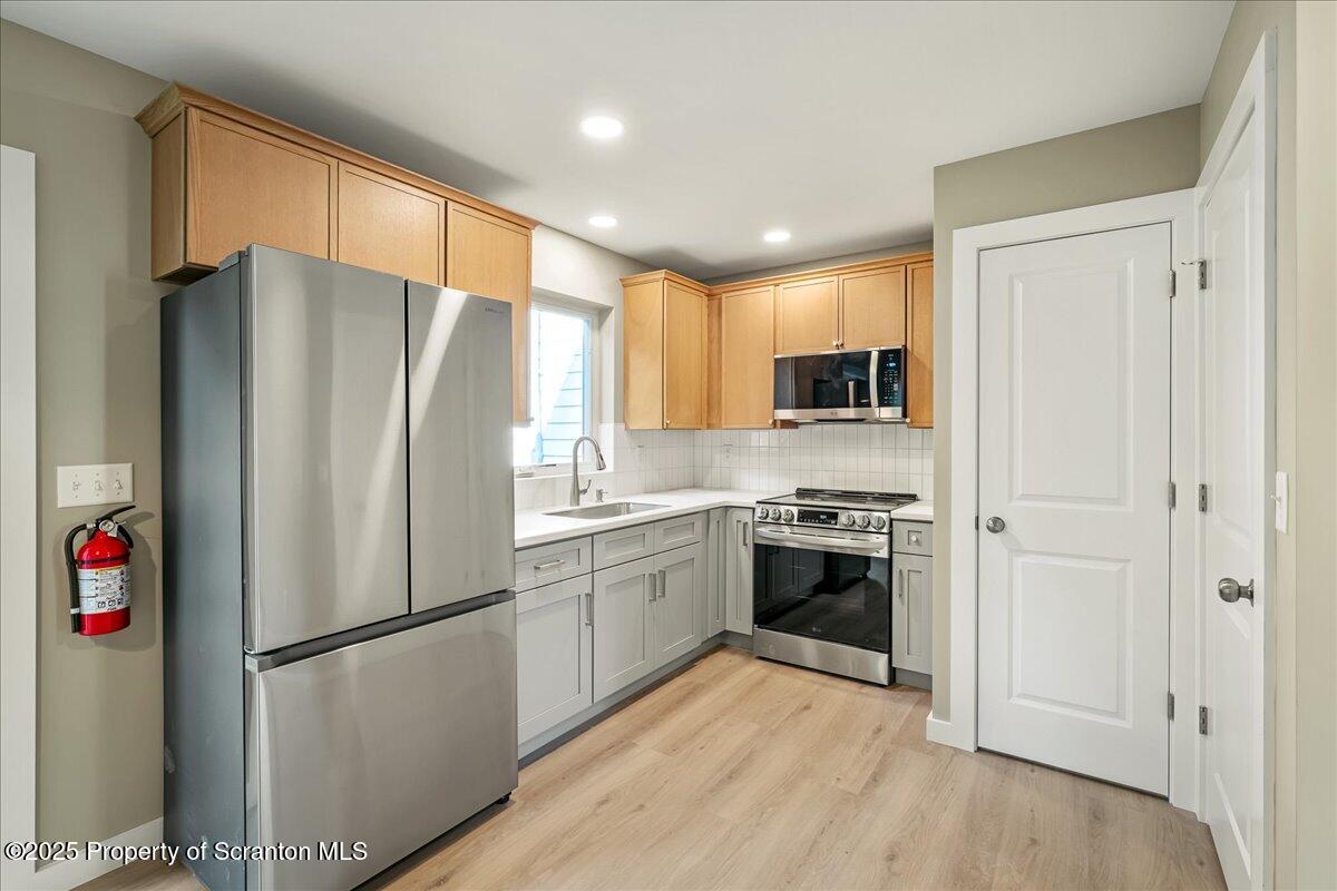 820 822 Delaware Street Scranton, PA 18509 - Photo 11 of 48 a kitchen with stainless steel appliances a refrigerator a stove top oven a sink and cabinets