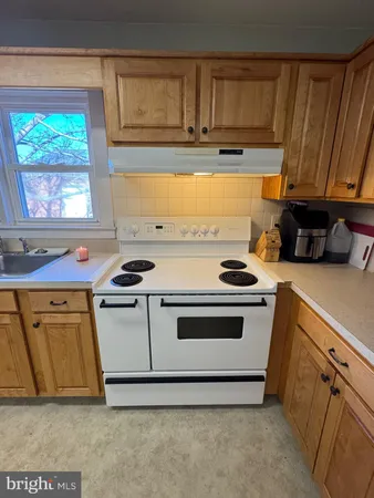 a kitchen with a stove a sink and a window
