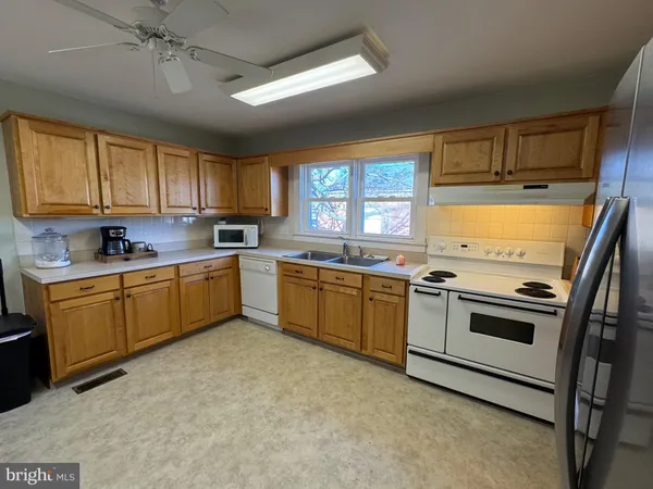 a kitchen with a refrigerator sink and cabinets