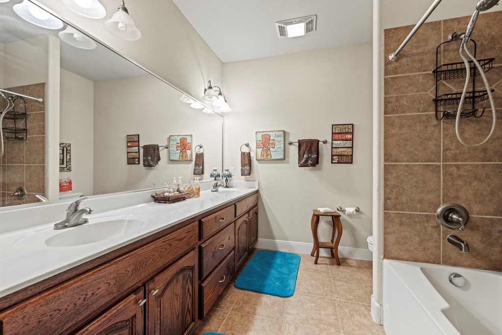 2250 Otte Road Stonewall, TX 78671 - Photo 12 of 35 a bathroom with a double vanity sink a mirror and a bathtub