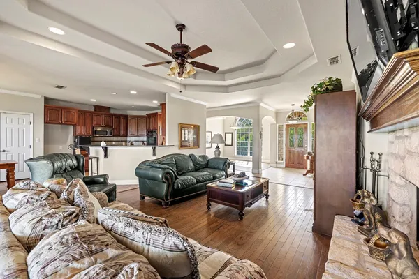 a living room with furniture kitchen view and a chandelier