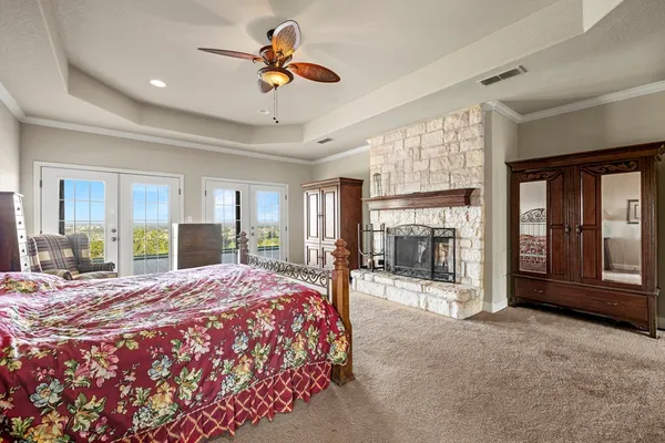 a bedroom with a balcony a bed and a large window