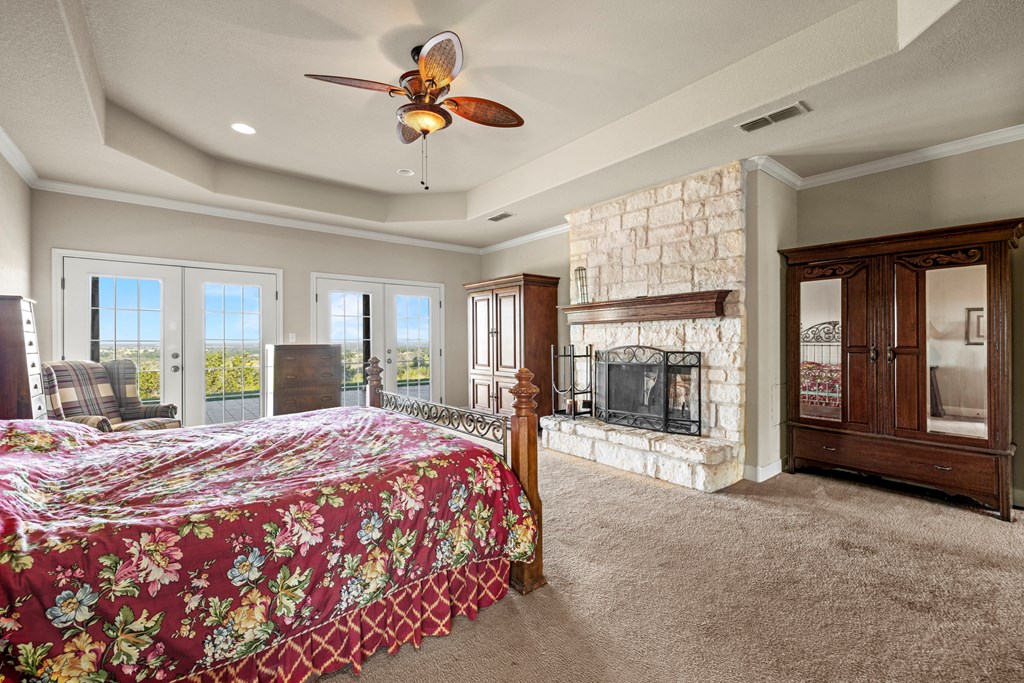 2250 Otte Road Stonewall, TX 78671 - Photo 8 of 35 a bedroom with a balcony a bed and a large window