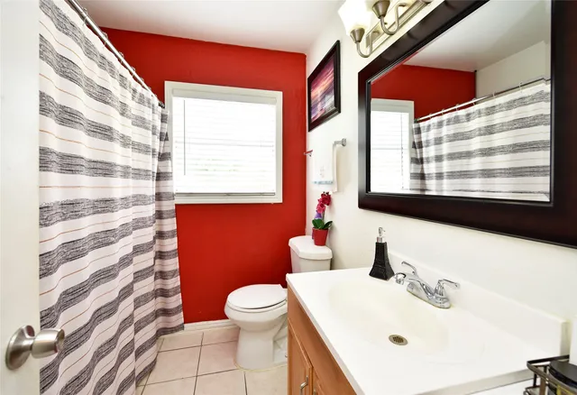 a bathroom with a sink a toilet and a window