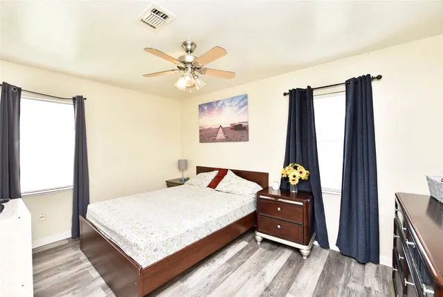 a bedroom with a bed and wooden floor