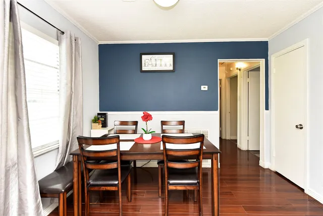 a dining room with furniture and wooden floor