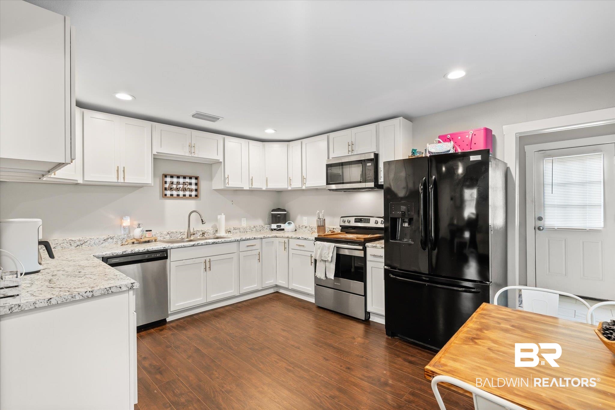 419 Pierce Street Saraland, AL 36571 - Photo 5 of 21 Kitchen featuring sink, white cabinetry, light stone counters, appliances with stainless steel finishes, and dark hardwood / wood-style flooring