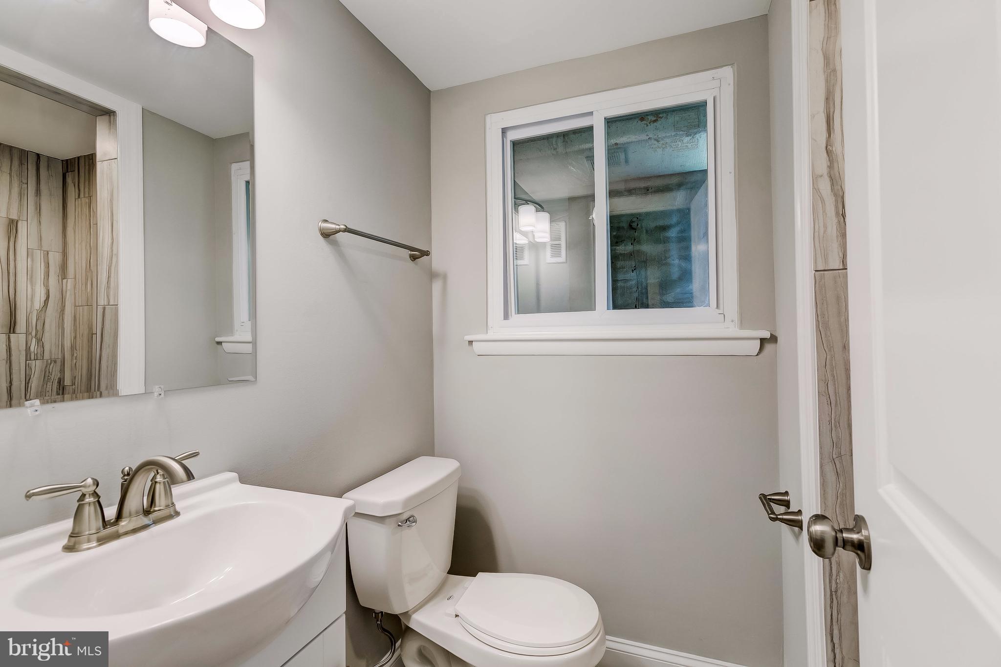 625 Edwards Road Annapolis, MD 21409 - Photo 24 of 30 a bathroom with a sink mirror toilet and shower