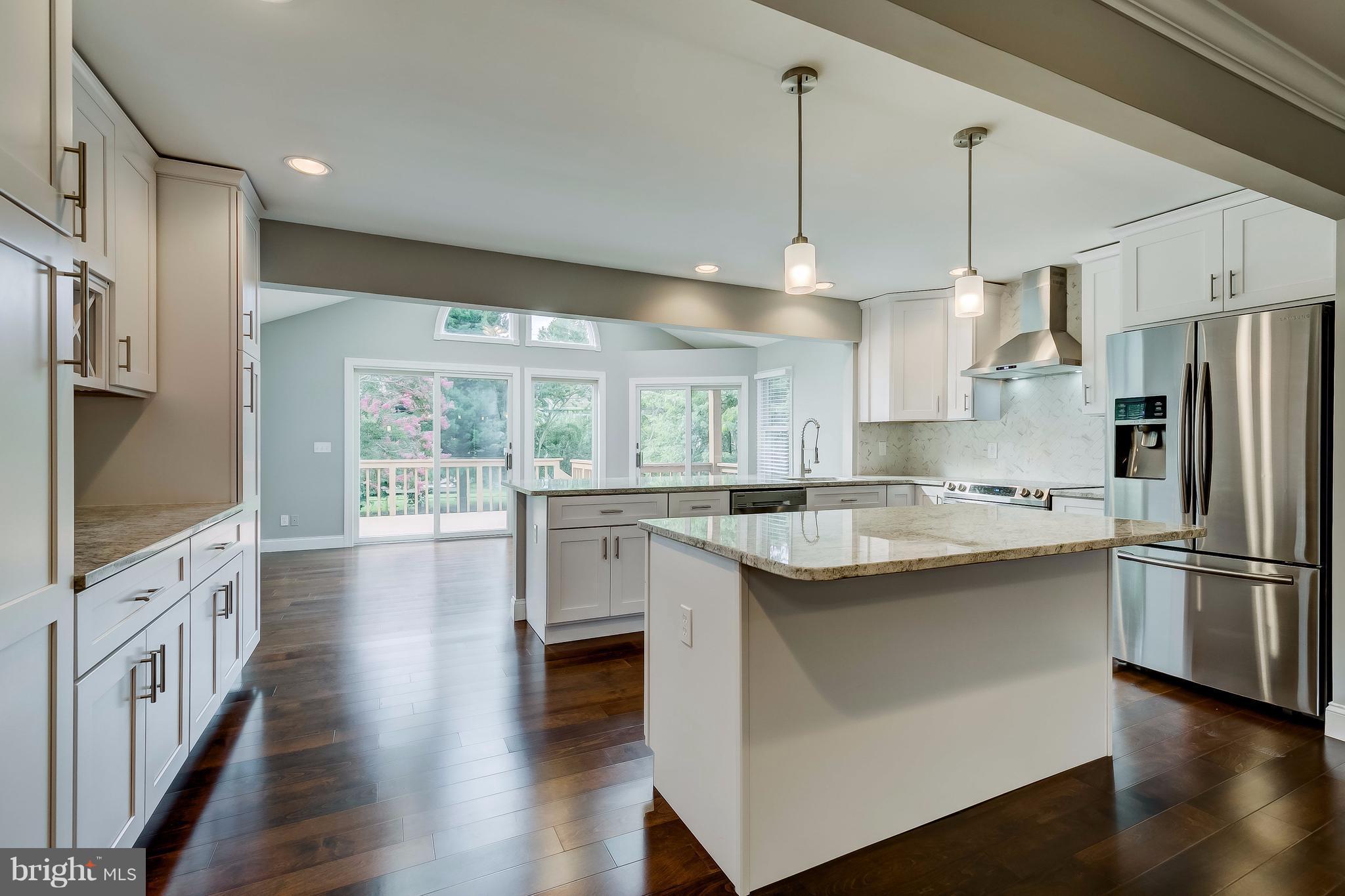 625 Edwards Road Annapolis, MD 21409 - Photo 5 of 30 a kitchen with stainless steel appliances a stove a sink dishwasher a refrigerator white cabinets wooden floor and a fireplace