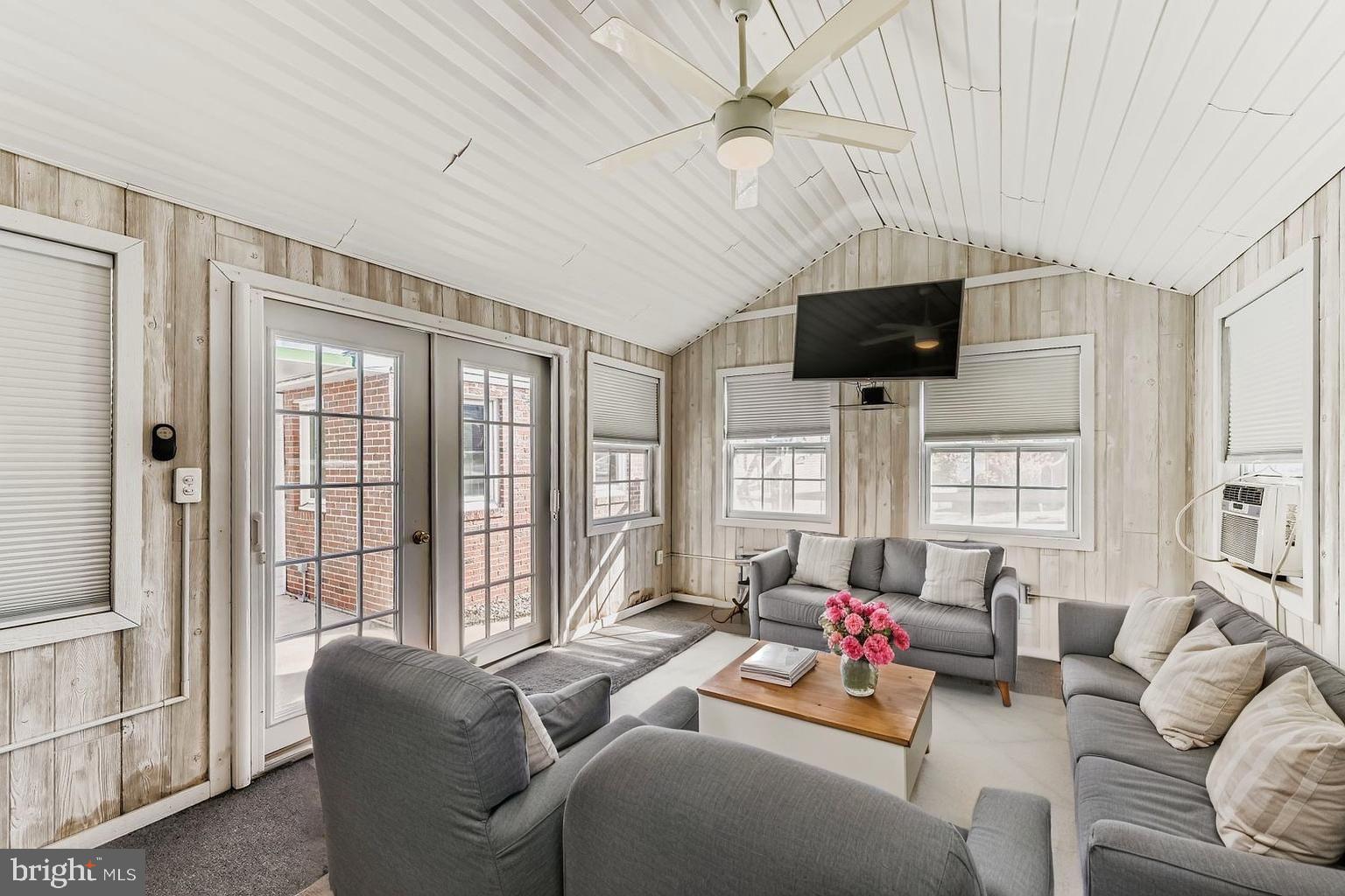 8004 Sagramore Road Rosedale, MD 21237 - Photo 26 of 34 a living room with furniture a flat screen tv and a floor to ceiling window