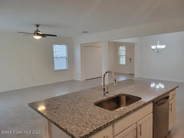 a kitchen with granite countertop a refrigerator and a sink