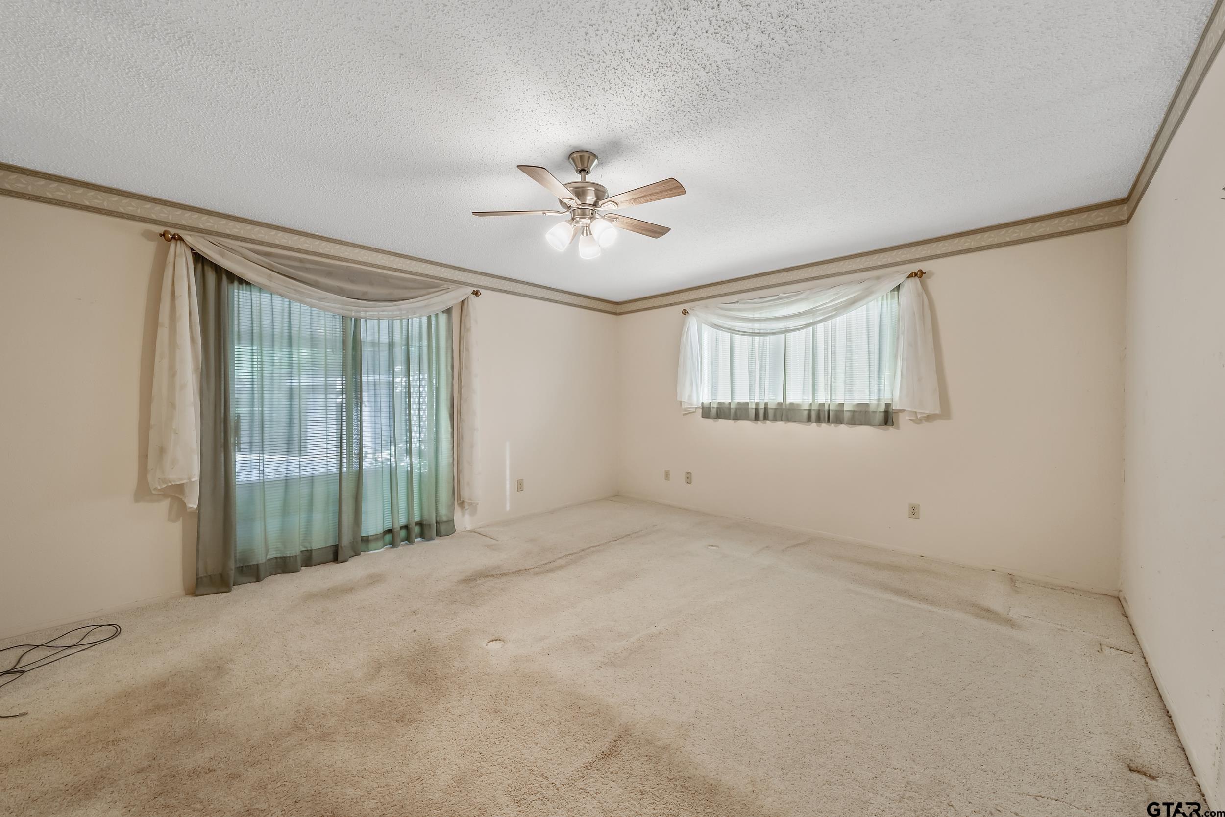 331 Bent Horseshoe Lane Holly Lake Ranch, TX 75765 - Photo 35 of 44 an empty room with chandelier fan and windows