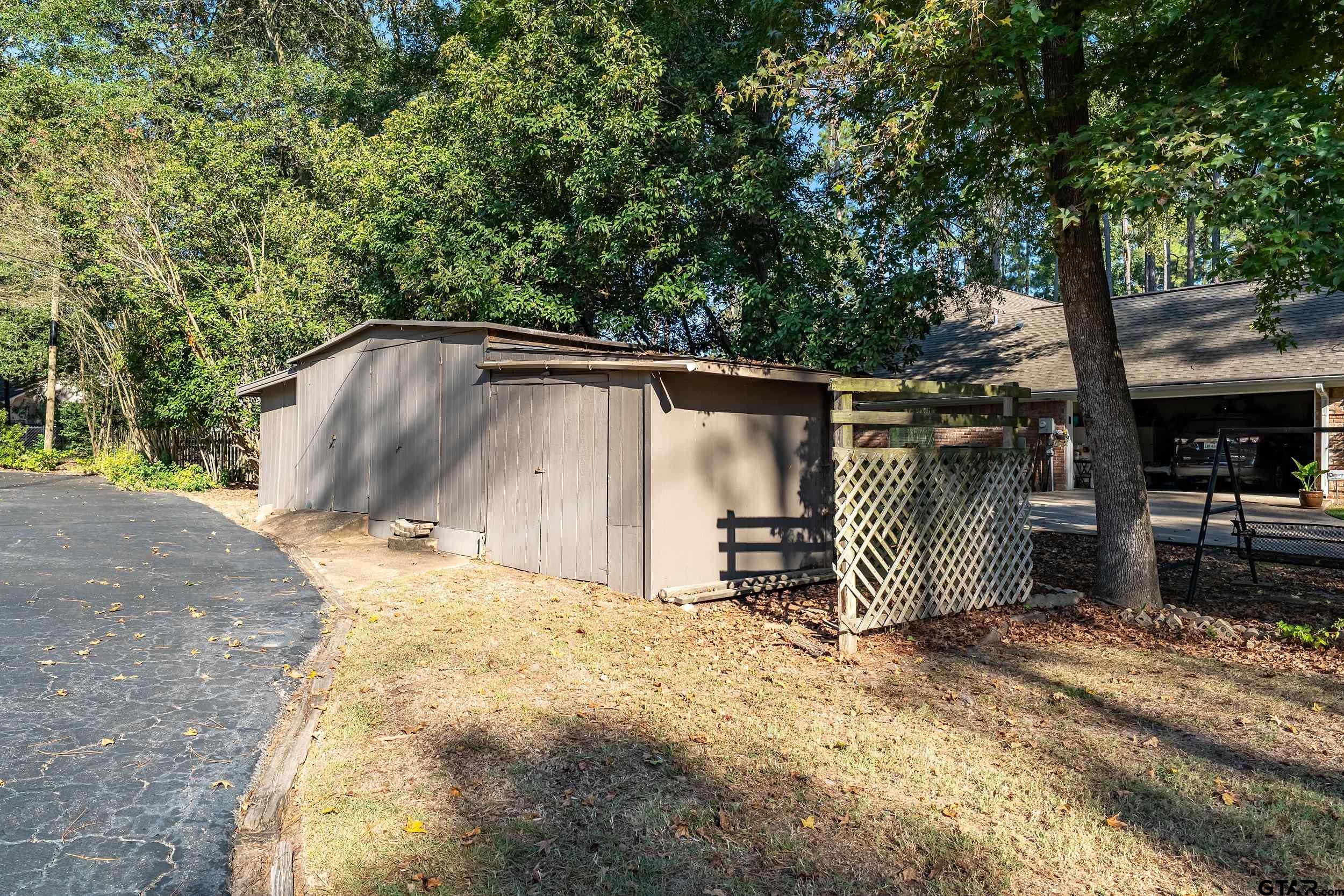 331 Bent Horseshoe Lane Holly Lake Ranch, TX 75765 - Photo 38 of 44 a backyard of a house with barbeque oven and table