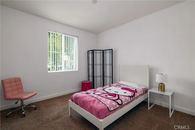 a bedroom with a bed chair and a window