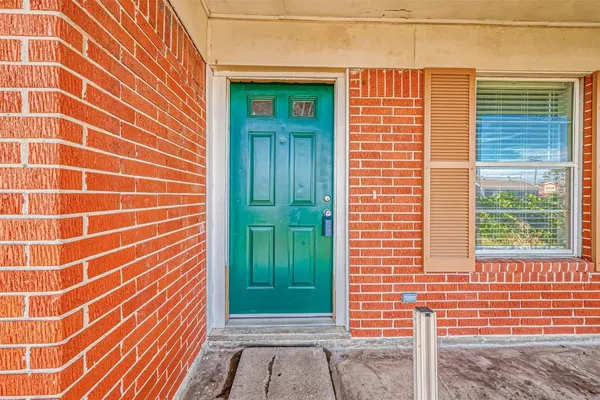 a view of a brick house with a window and a door