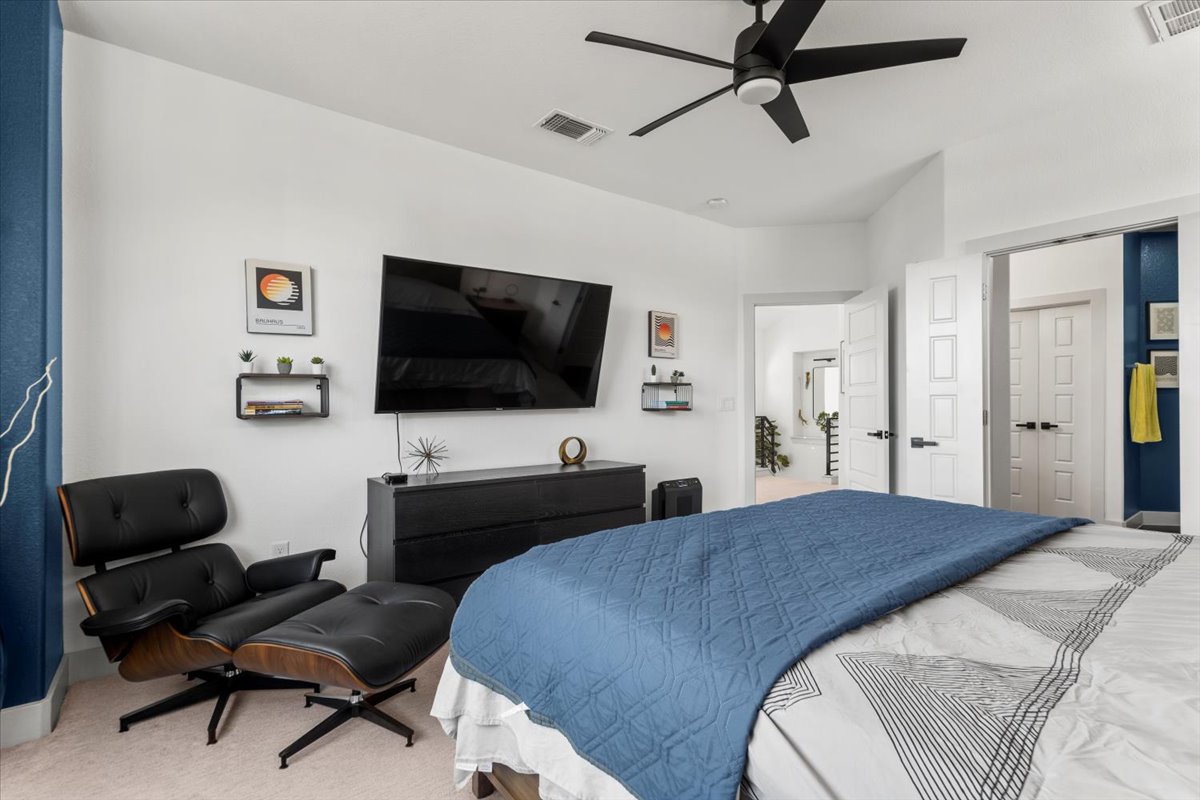 6912 Cardinal Bloom Loop Austin, TX 78744 - Photo 25 of 33 An inviting bedroom with plush carpeting features a ceiling fan for comfort and convenient interior doors leading to other spaces.