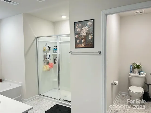 a bathroom with a toilet and a shower