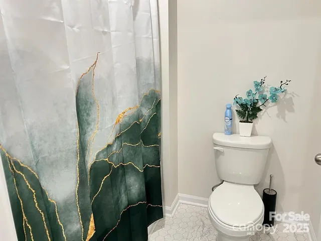 a white toilet sitting next to a shower
