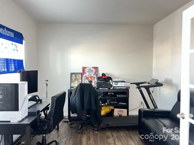 a view of a workspace with furniture and a gym cycle