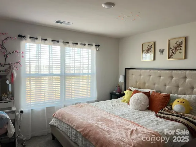 a bed sitting in a bedroom next to a window