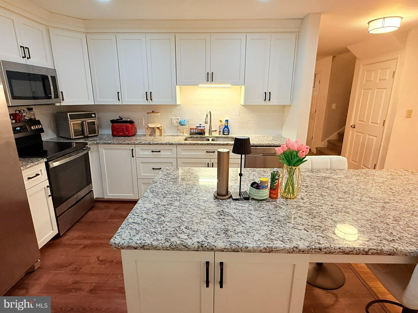 242 Spring Street State College, PA 16801 - Photo 17 of 75 a kitchen with granite countertop a sink a stove and cabinets