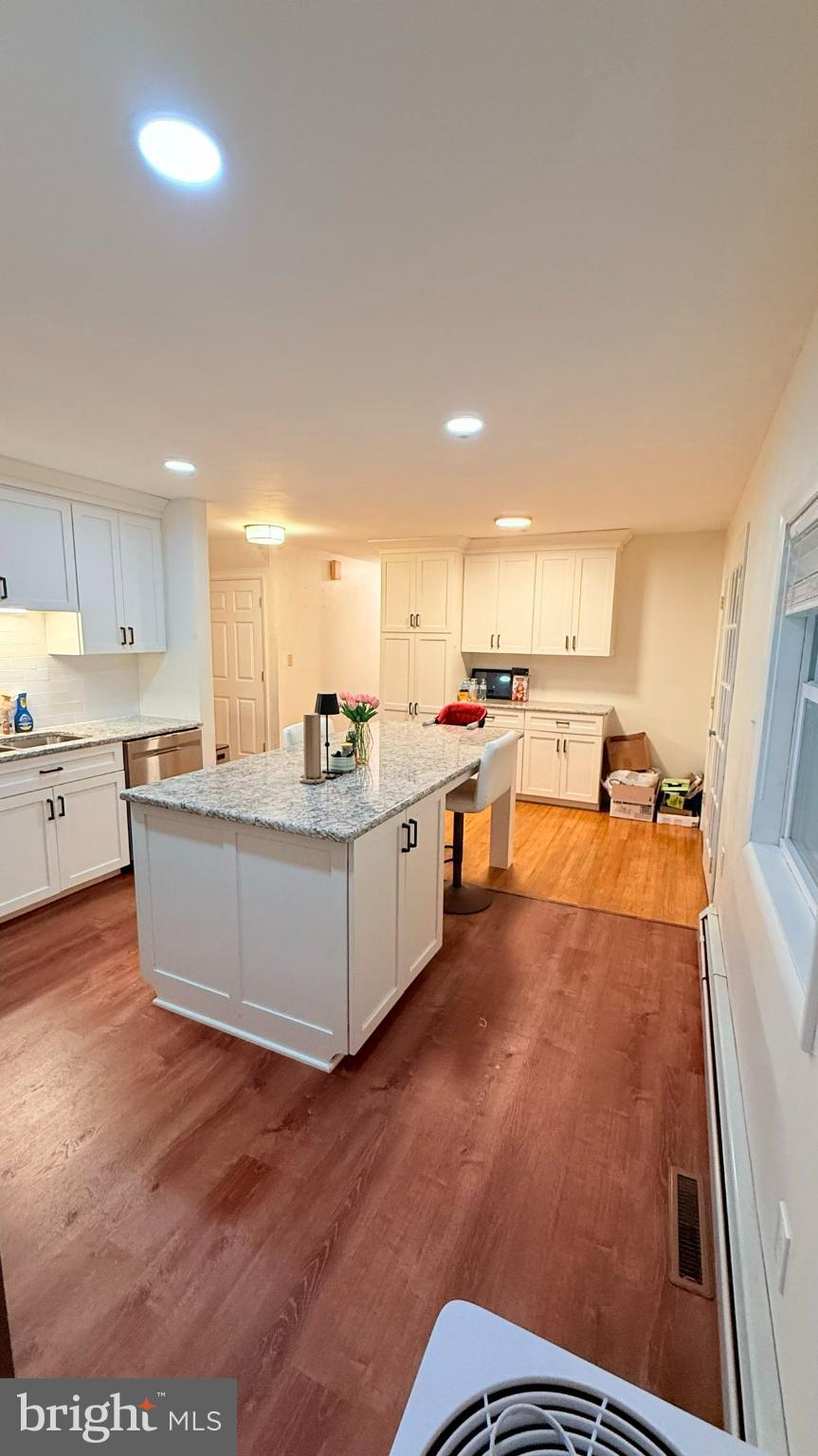 242 Spring Street State College, PA 16801 - Photo 18 of 75 a living room with stainless steel appliances kitchen island granite countertop a stove a sink a refrigerator and white cabinets with wooden floor
