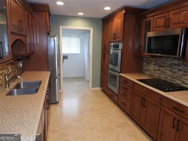 a kitchen with stainless steel appliances granite countertop a refrigerator and a sink