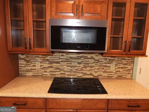 a kitchen with granite countertop stainless steel appliances a stove and a microwave