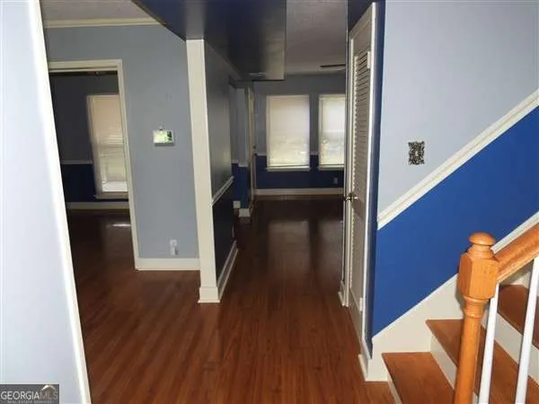 a view of a hallway with wooden floor and staircase