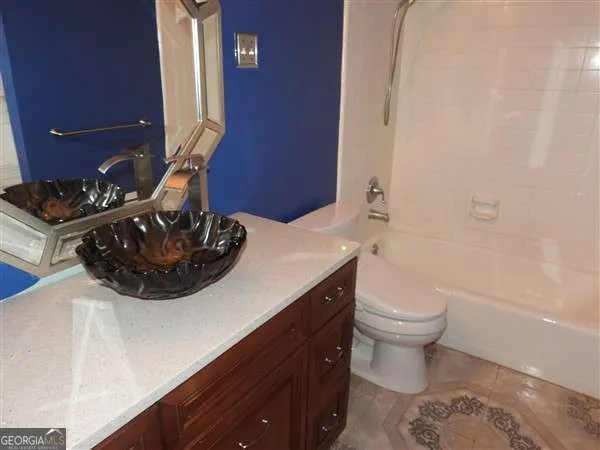 a bathroom with a sink a toilet and mirror