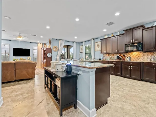 a kitchen with stainless steel appliances kitchen island granite countertop a sink and cabinets