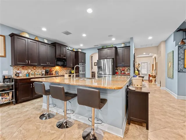a kitchen with stainless steel appliances granite countertop a refrigerator and a stove top oven