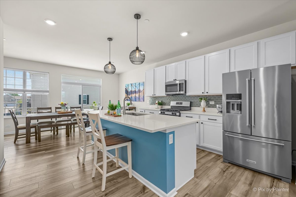 1623 BENTZ Way Batavia, IL 60510 - Photo 2 of 29 a kitchen with stainless steel appliances granite countertop a stove a refrigerator a kitchen island a dining table and chairs with wooden floor