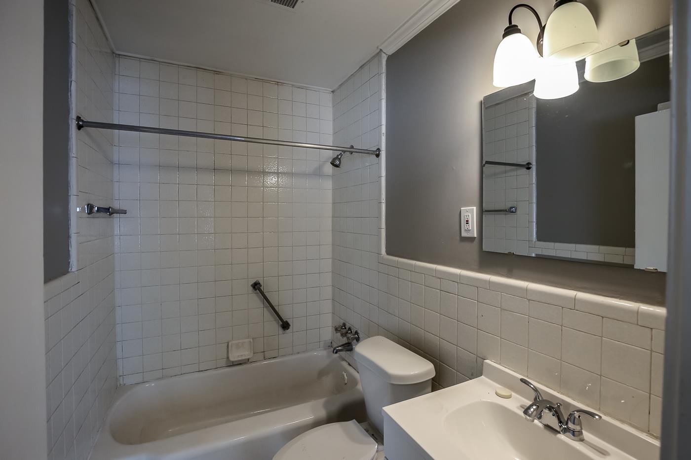 746 Waring Road Memphis, TN 38122 - Photo 5 of 16 Full bathroom featuring tasteful backsplash, tile walls, sink, tiled shower / bath combo, and toilet