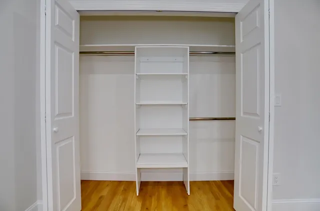 a view of walk in closet with empty racks