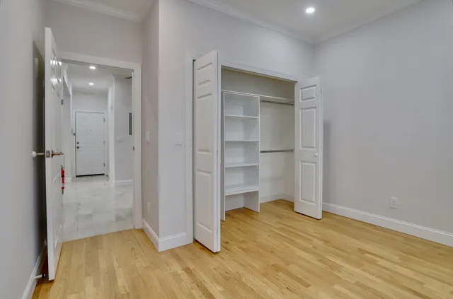 a view of empty room with wooden floor and cabinet