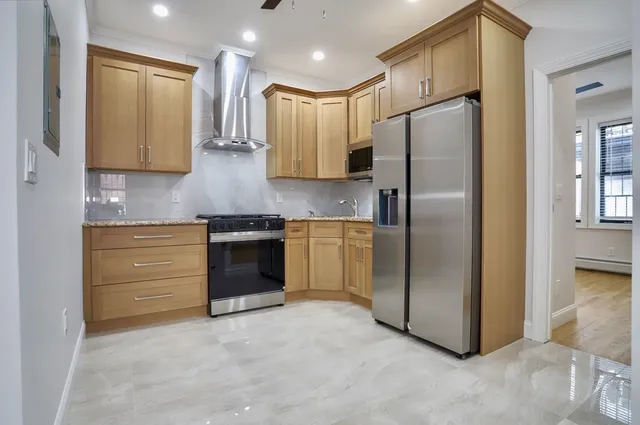 a kitchen with stainless steel appliances granite countertop a refrigerator a sink and a stove