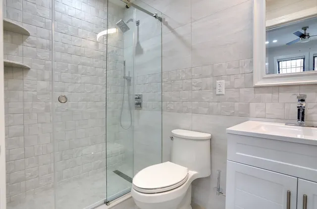 a bathroom with a toilet a sink a shower and mirror