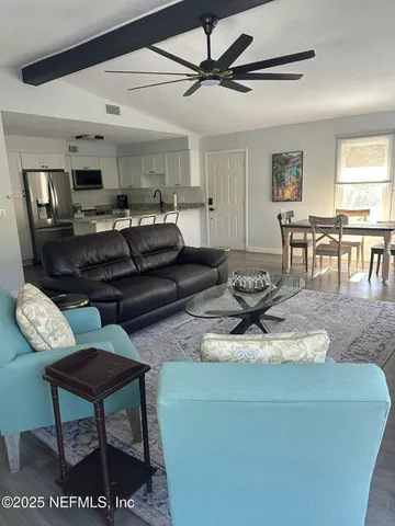 a living room with furniture and a dining table with kitchen view