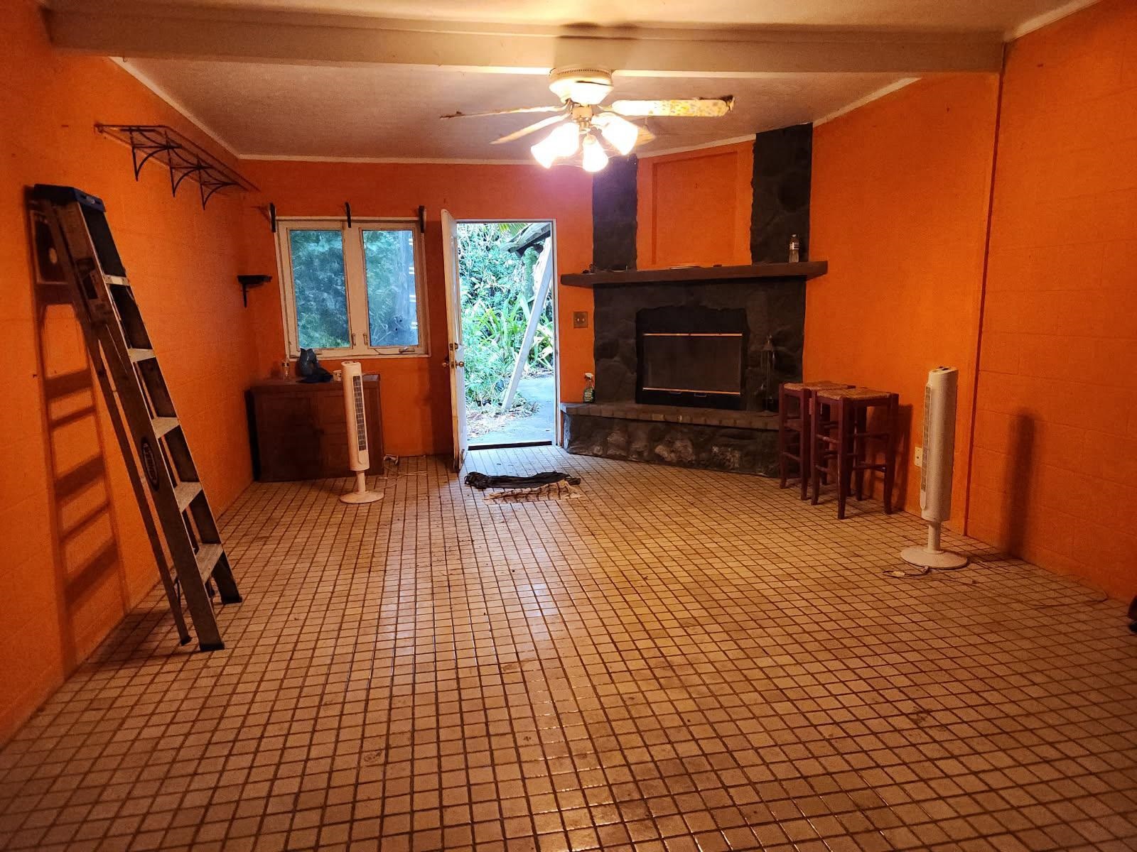 a view of an empty room with a fireplace and a window