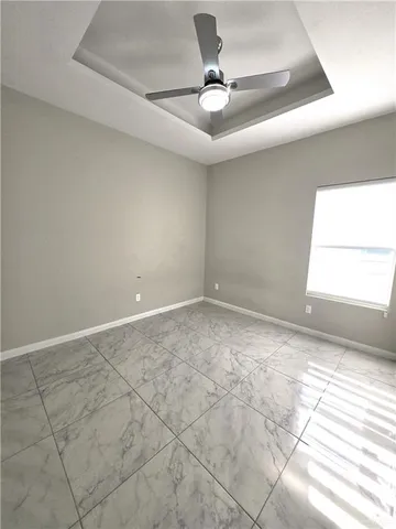 an empty room with a window and a ceiling fan