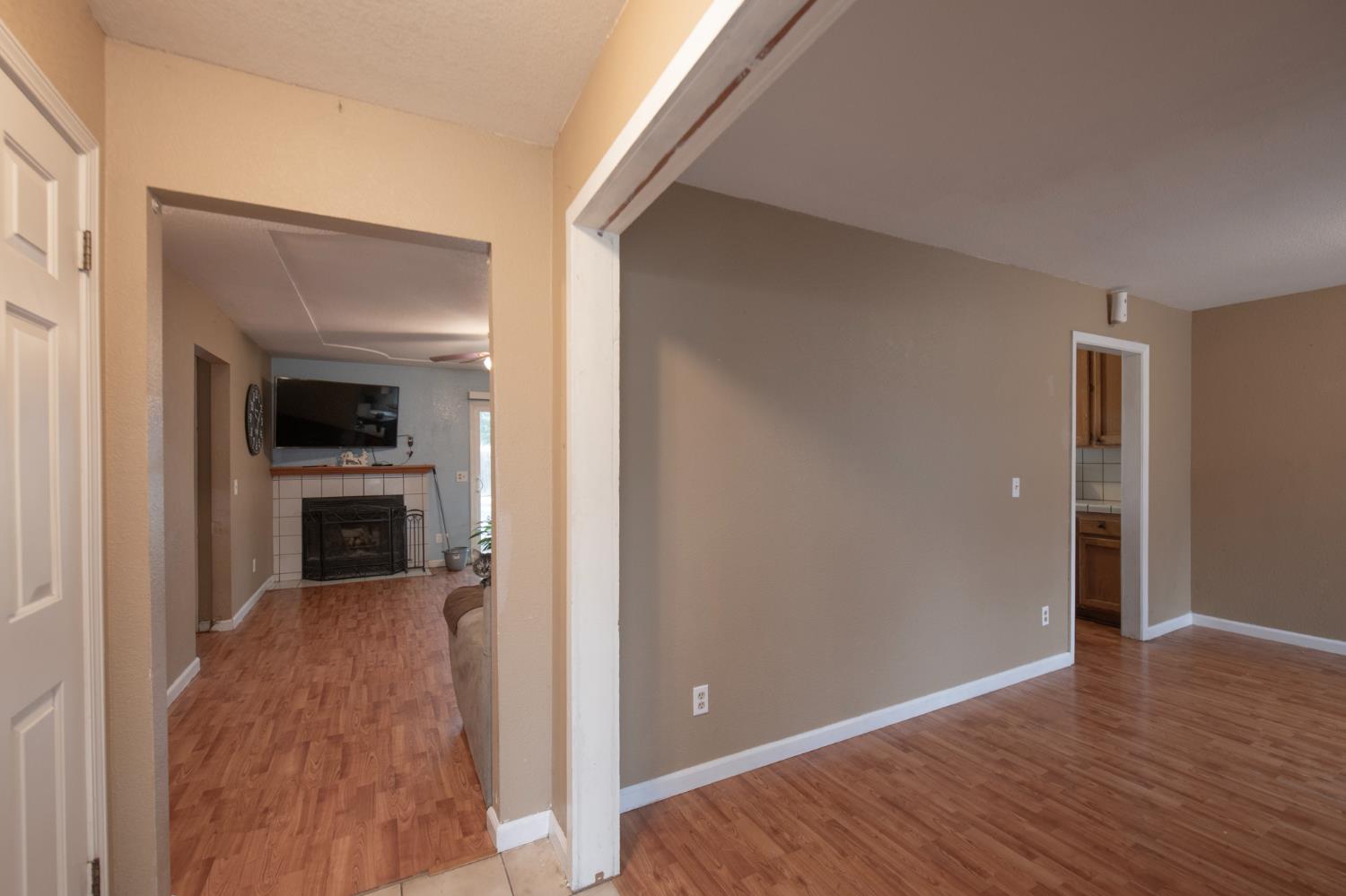 14531 West Kearney Boulevard Kerman, CA 93630 - Photo 19 of 22 a view of a hallway view with wooden floor and a fireplace
