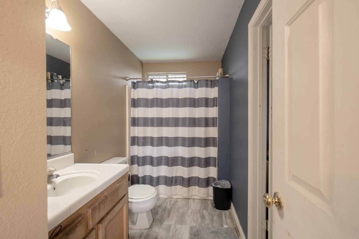 14531 West Kearney Boulevard Kerman, CA 93630 - Photo 22 of 22 a bathroom with a granite countertop toilet a sink and a mirror