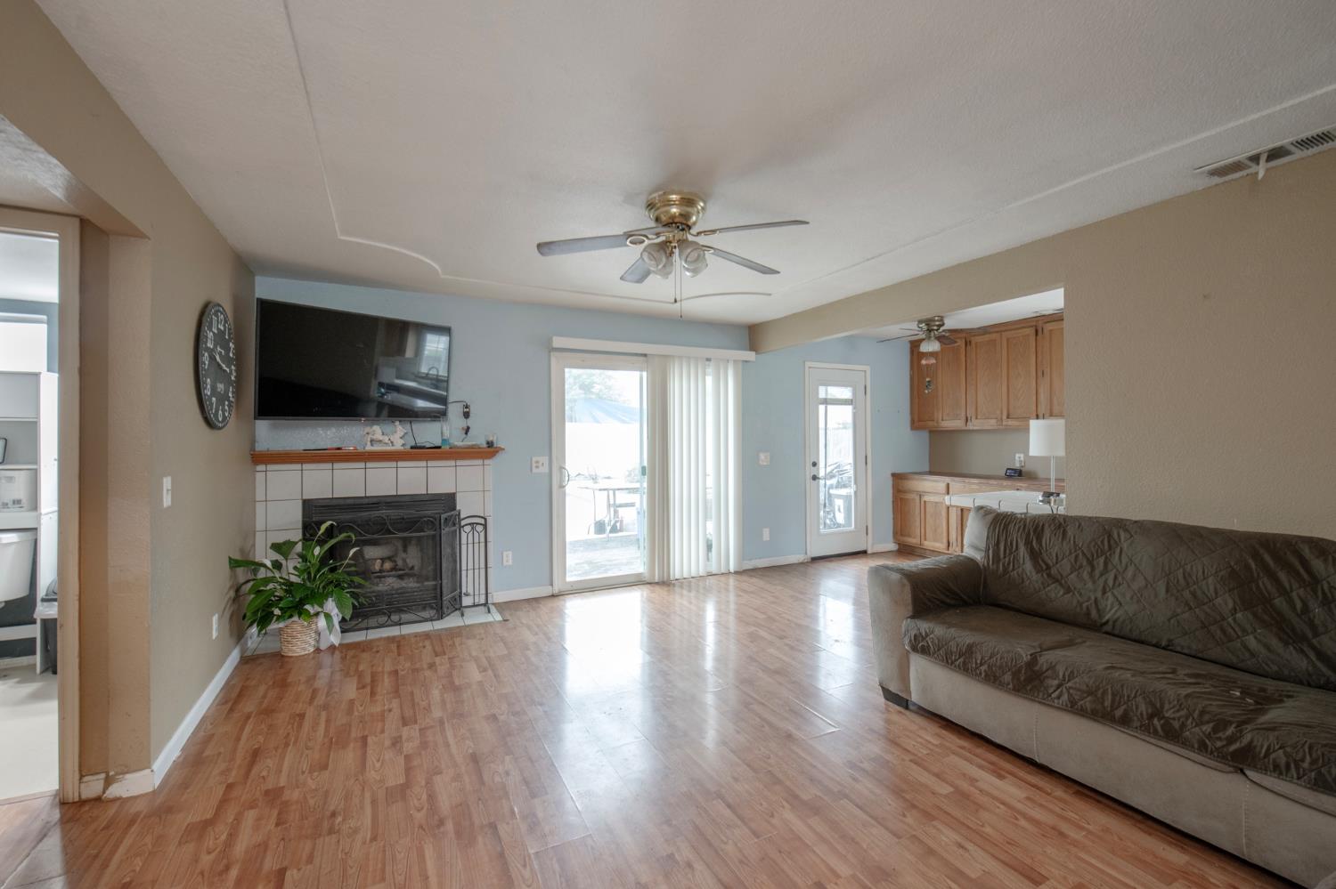 14531 West Kearney Boulevard Kerman, CA 93630 - Photo 7 of 22 a living room with furniture a fireplace and a flat screen tv